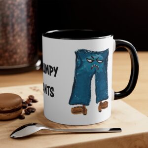 Photograph depicting the Grumpy Pants coffee mug sitting on a wooden counter top with a spoon and a cookie.