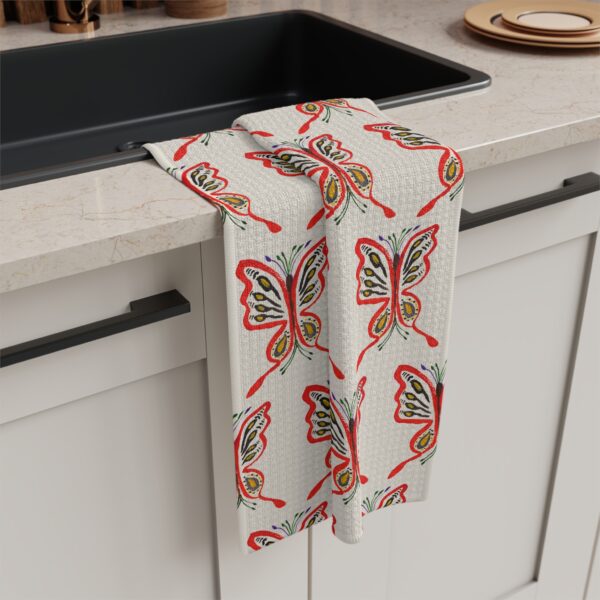 soft cream tea towel featuring Paul Myrick's butterfly artwork in a printed pattern - shown hanging on a kitchen sink
