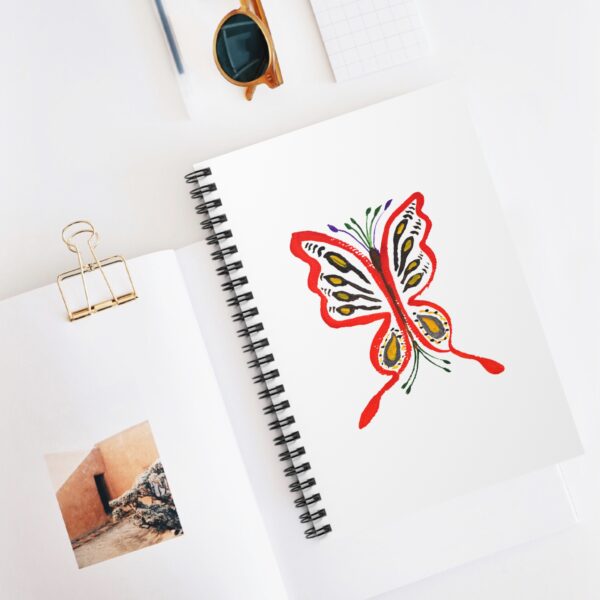 white spiral notebook featuring Paul Myrick's butterfly artwork on the cover